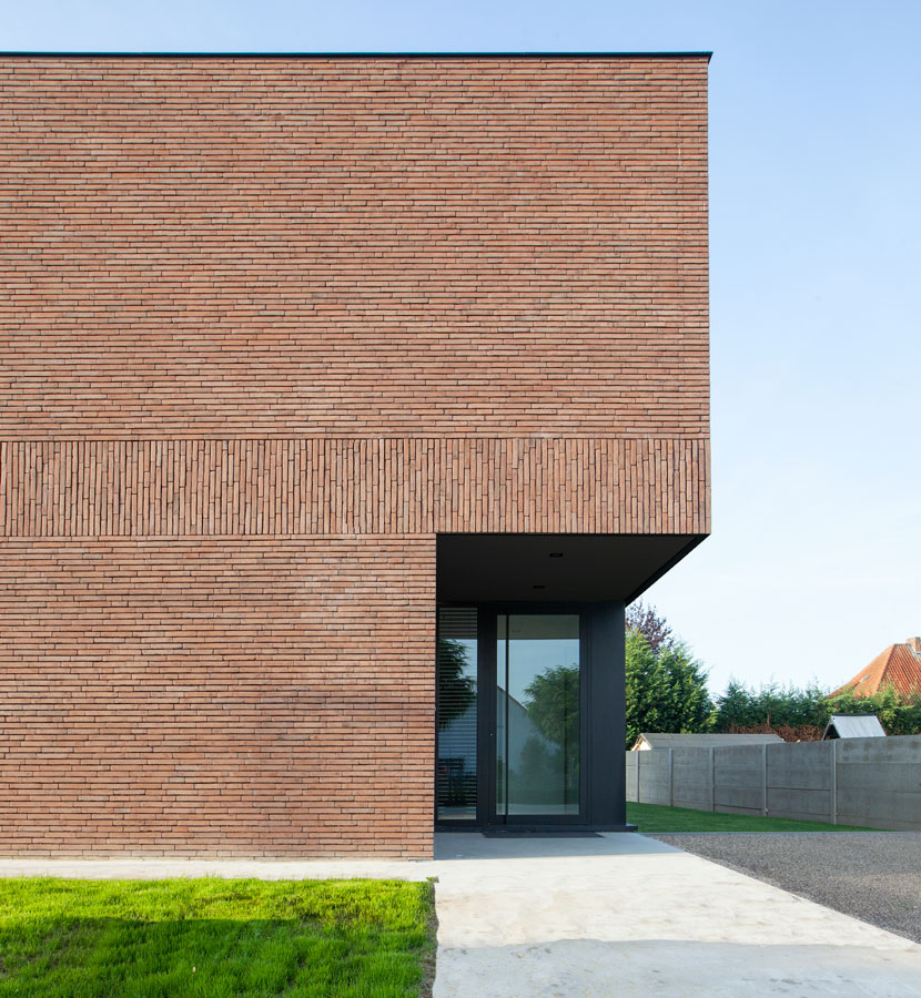 Woning CC in Rekem, bakstenen facade met glazen voordeur